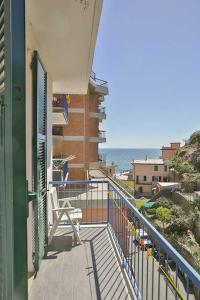 a balcony with a chair and a view of the ocean at Jolly Roger Riomaggiore in Riomaggiore