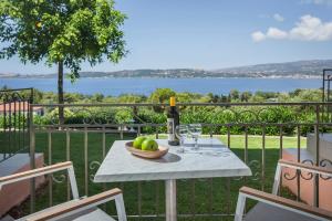 uma mesa com uma tigela de maçãs e uma garrafa de vinho em Panorama Fanari studios and apartments em Argostoli