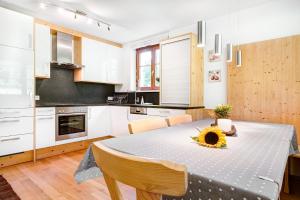 - une cuisine avec une table et un tournesol dans l'établissement Gartenappartement Füchsle by A-Appartments, à Brand