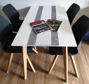 una mesa blanca con 2 revistas y 2 sillas en Zum Himmelreich, en Wutha-Farnroda
