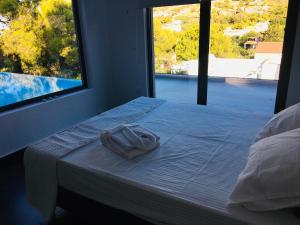 a bed with a towel on it in a room with a window at Villa tranquility in Lagonissi