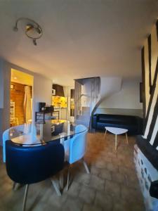 una sala de estar con una mesa y un sofá en Gîtes la Conterie, en Fatouville-Grestain