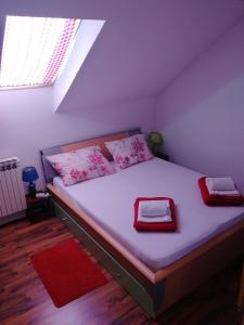 a bedroom with a large bed with pink pillows at Apartman Danijel Jagic in Petrinja