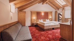 une chambre d'hôtel avec deux lits et un canapé dans l'établissement Hotel Auhof Kappl, à Kappl