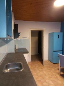 eine Küche mit einer Theke und einem blauen Kühlschrank in der Unterkunft Ferienwohnung Brenderweg in Koblenz + 22 Fotos