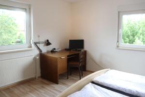 1 dormitorio con escritorio, ordenador y cama en Haus-Dorfidyll, en Spangenberg