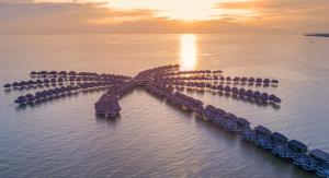 an island in the water at sunset at Golden Palm Tree Sepang in Sepang