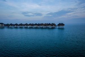 a row of houses on a pier over the water at Golden Palm Tree Sepang in Sepang