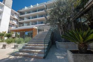 a staircase leading up to a building with a tree at Poseidon The Beach Hotel in Budva