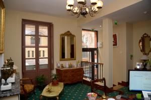 a living room with a desk and a mirror and a door at Hôtel Héliot, Cosy Places by Charme & Caractère in Toulouse