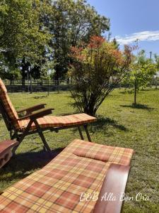 een houten bankje in een park naast een veld bij B&B Alla Bon'ora in Volpago del Montello