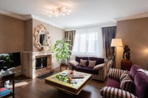 a living room with purple furniture and a fireplace at Hôtel de la Cigogne in Geneva