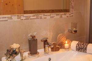 a bathroom sink with a candle and a glass of wine at Untertalhof in Castelrotto
