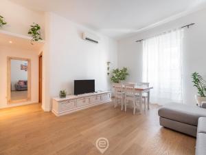 salon z telewizorem i stołem z krzesłami w obiekcie La Finestra sul Corso w Cagliari