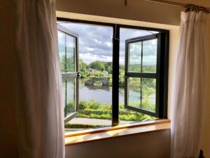 an open window with a view of a river at Cael Uisce apartment 31 Cliff road in Belleek