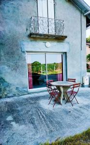 Albias的住宿－Domaine de Montels，一张桌子和椅子,位于一座带窗户的建筑前