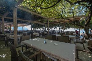 a restaurant with a table and chairs and trees at Poseidon The Beach Hotel in Budva