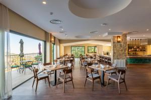 a restaurant with tables and chairs and a balcony at Petit Palais Platres Boutique Hotel in Platres