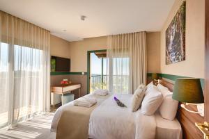 a bedroom with a large white bed with a window at Petit Palais Platres Boutique Hotel in Platres