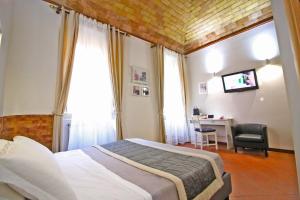 ローマにあるMachiavelli Suitesのベッドルーム1室(ベッド1台、デスク、椅子付)