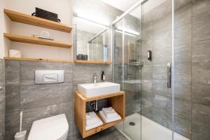 La salle de bains est pourvue d'un lavabo et d'une douche. dans l'établissement Hotel Meiringen, à Meiringen