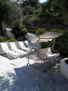 a group of lounge chairs and an umbrella at Stafylos Rooms in Stafylos