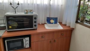 a microwave sitting on top of a wooden cabinet at Zohar's Apartment in Haifa