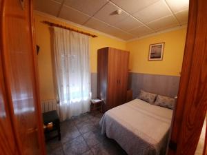 a small bedroom with a bed and a window at Hostal Alba in Albacete