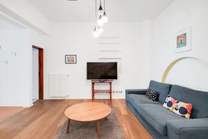 een woonkamer met een blauwe bank en een tafel bij Santa Reparata Apartment with Patio and Terrace in Florence