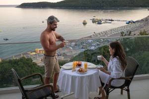 a man and a woman sitting at a table with wine glasses at Poseidon The Beach Hotel in Budva