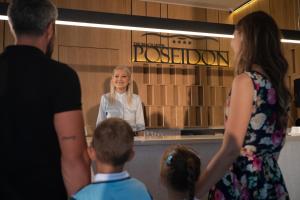 a woman standing in front of a mirror at Poseidon The Beach Hotel in Budva
