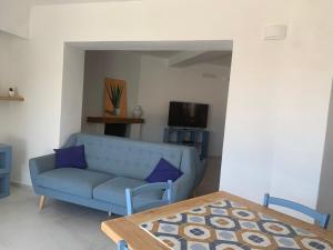 sala de estar con sofá azul y mesa en Bona Ciurrata, en Golfo Aranci