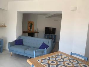 a living room with a blue couch and a table at Bona Ciurrata in Golfo Aranci