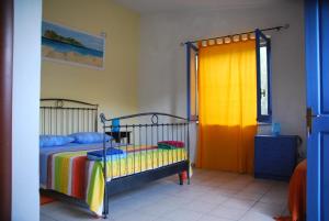 a bedroom with a bed and a yellow curtain at B&B Sa Tuerra in Teulada