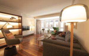 ein Wohnzimmer mit einem Sofa, Stühlen und einer Lampe in der Unterkunft Aletxo's Home in San Sebastián