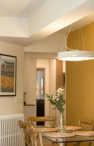 ein Esszimmer mit einem Tisch mit einer Vase mit Blumen in der Unterkunft Aletxo's Home in San Sebastián