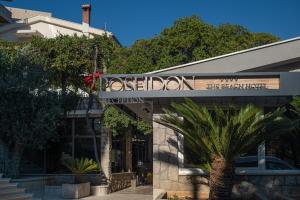 a sign for a restaurant in front of a building at Poseidon The Beach Hotel in Budva