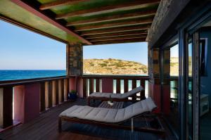 a balcony with a couch and a view of the ocean at Villa Menelaos Penthouse in Mochlos