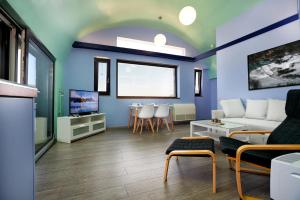 a living room with a couch and a table at Villa Menelaos Penthouse in Mochlos
