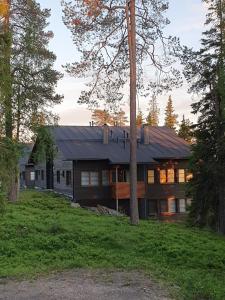 ein Haus mit einem schwarzen Dach in einem Wald in der Unterkunft Karhunvartijan Kartano 3 B 1, Rukan keskusta in Ruka