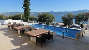 a patio with tables and chairs next to a swimming pool at Villa Ana in Slatine