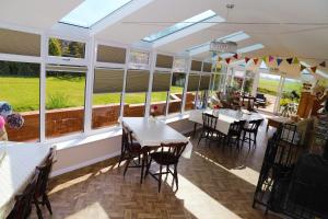 a restaurant with tables and chairs and windows at Elmfield House in Bedale