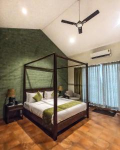 a bedroom with a bed and a ceiling fan at The Summer House, Pachmarhi - AM Hotel Kollection in Pachmarhī