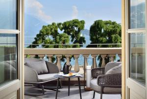 a room with a balcony with chairs and a table at Grand Hotel Victoria concept & spa, by R Collection Hotels in Menaggio