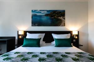 Postel nebo postele na pokoji v ubytování Hôtel Corniche du Liouquet