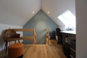 Zimmer im Dachgeschoss mit einem Schreibtisch, einem Stuhl und einem Tisch in der Unterkunft De Oude Kaasmakerij 'de ast' in Passendale