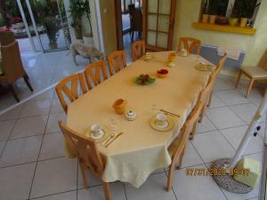 a dining room table with a dog in the background at Locatlantique in Aytré