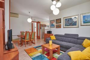 a living room with a couch and a table at Family Apartment Dubrovnik - private jacuzzi terrace, private parking in Dubrovnik