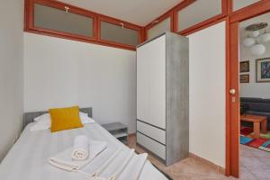 a bedroom with a bed with a yellow pillow at Family Apartment Dubrovnik - private jacuzzi terrace, private parking in Dubrovnik