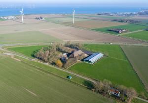 an aerial view of a farm with wind turbines at Chalet Stal Veersedam in Kamperland